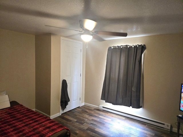 513 N E St, Poplar Bluff, MO 63901 - unfurnished bedroom with baseboard heating, a textured ceiling, dark wood finished floors, ceiling fan, and baseboards