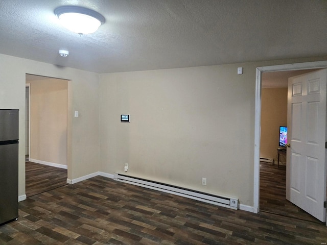 513 N E St, Poplar Bluff, MO 63901 - empty room with a baseboard radiator, wood finished floors, a textured ceiling, baseboards, and a smoke detector