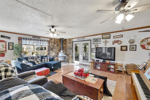 524 N St, Farmington, MO 63640 - living room featuring ceiling fan, french doors, light wood-style flooring, a wood stove, and a textured ceiling