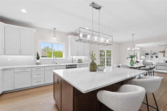 8 Briarbrook Trl, Saint Louis, MO 63131 - kitchen with a sink, a chandelier, a kitchen island, stainless steel dishwasher, and decorative backsplash