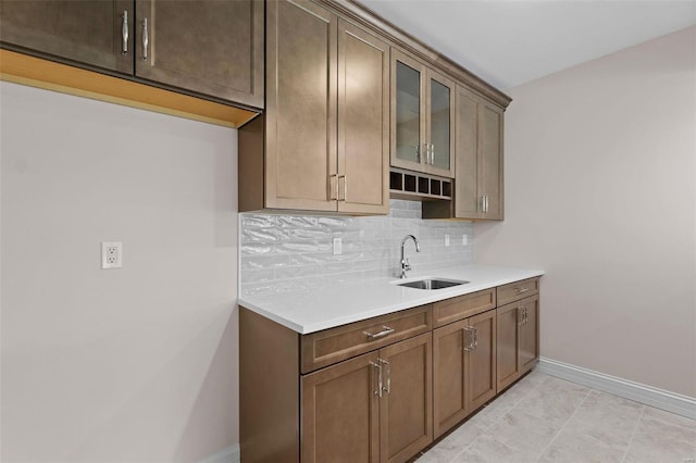 8 Briarbrook Trl, Saint Louis, MO 63131 - kitchen with glass insert cabinets, baseboards, a sink, backsplash, and light countertops