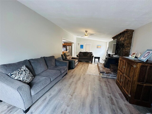 living room with wood finished floors and a ceiling fan