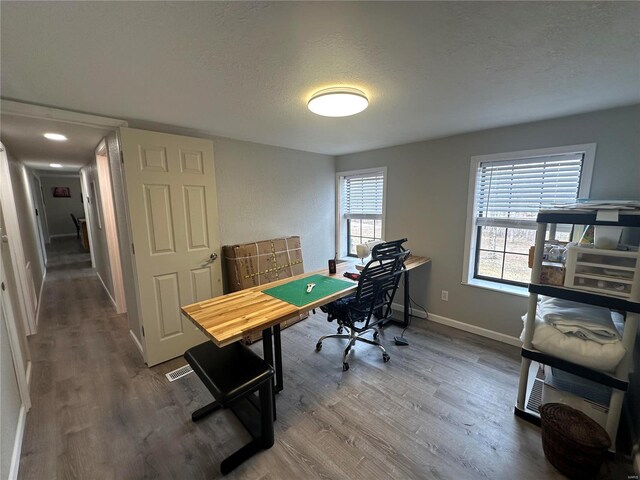 office featuring wood finished floors, a textured ceiling, and baseboards
