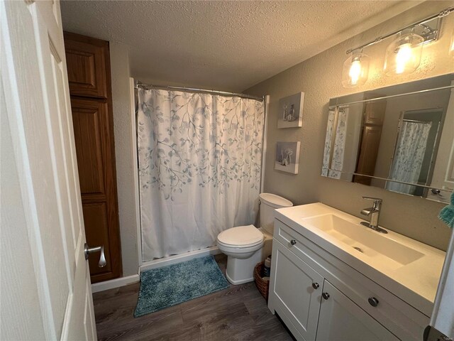 full bath featuring a textured ceiling, wood finished floors, vanity, a shower with curtain, and toilet