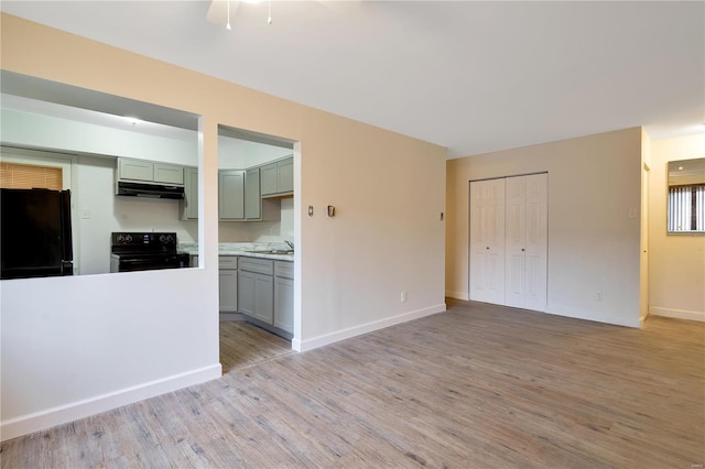 7579 Hazelcrest Dr Unit A, Hazelwood, MO 63042 - unfurnished living room featuring light wood finished floors, baseboards, and a sink