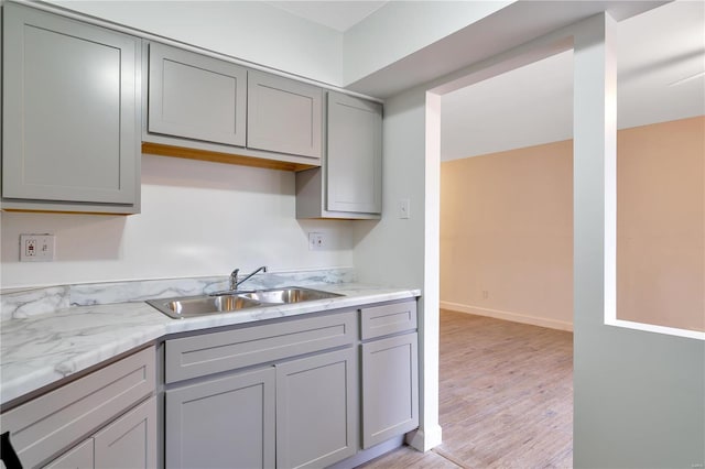 7579 Hazelcrest Dr Unit A, Hazelwood, MO 63042 - kitchen with a sink, gray cabinets, light wood-type flooring, and light stone countertops