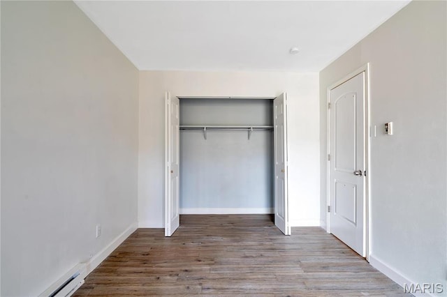 7579 Hazelcrest Dr Unit A, Hazelwood, MO 63042 - unfurnished bedroom featuring a closet, wood finished floors, baseboard heating, and baseboards