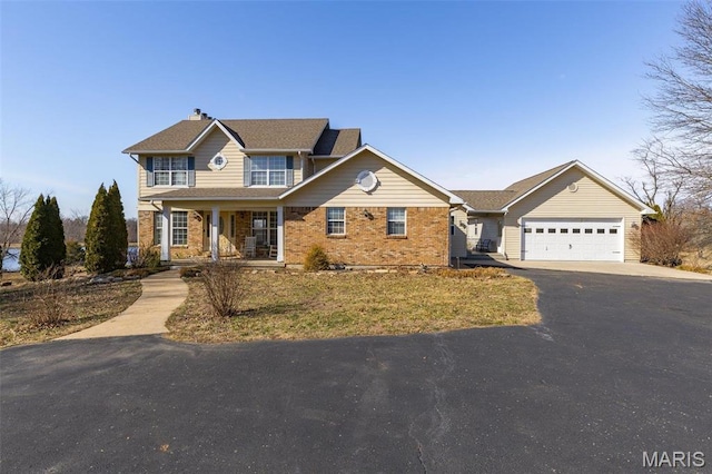4645 Quail Run Rd, Farmington, MO 63640 - traditional-style house featuring asphalt driveway, a porch, brick siding, and an attached garage