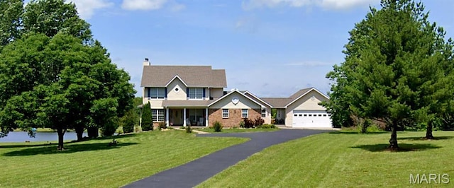 4645 Quail Run Rd, Farmington, MO 63640 - traditional-style house with a front yard, asphalt driveway, a garage, and a chimney