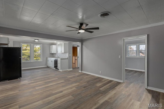 209 S Montgomery St, Gillespie, IL 62033 - unfurnished living room with ornamental molding, a ceiling fan, dark wood-style flooring, baseboards, and a barn door