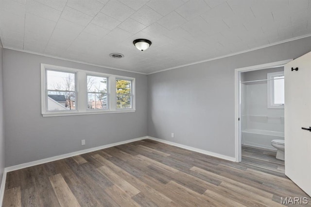 209 S Montgomery St, Gillespie, IL 62033 - unfurnished bedroom with crown molding, multiple windows, wood finished floors, and baseboards