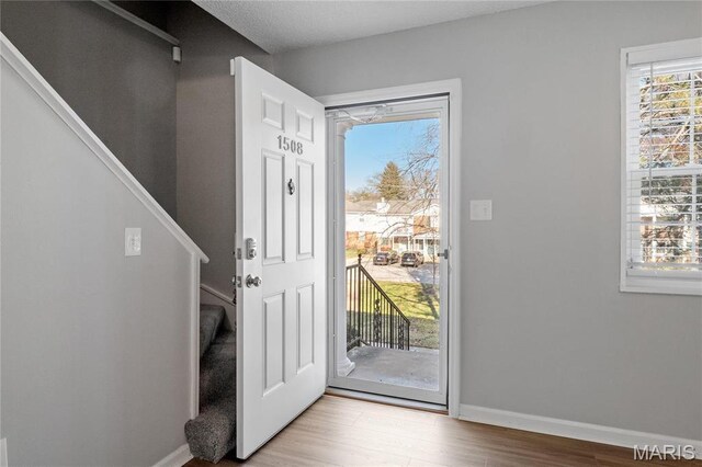 1508 Swallow Dr, Saint Louis, MO 63144 - entrance foyer with stairway, wood finished floors, and baseboards