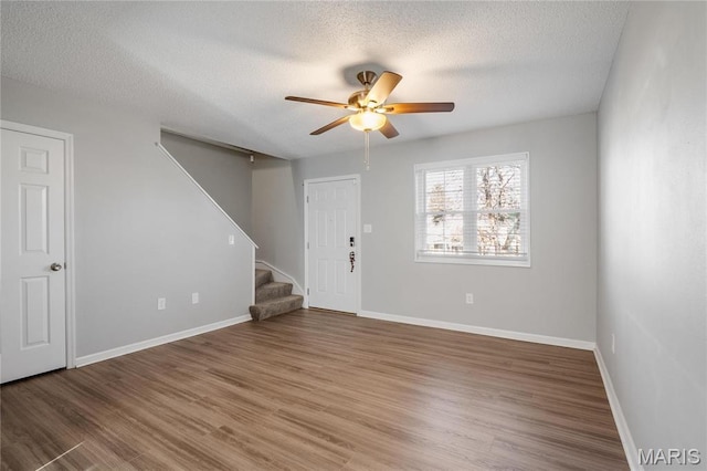 1508 Swallow Dr, Saint Louis, MO 63144 - entryway with stairway, a ceiling fan, a textured ceiling, wood finished floors, and baseboards