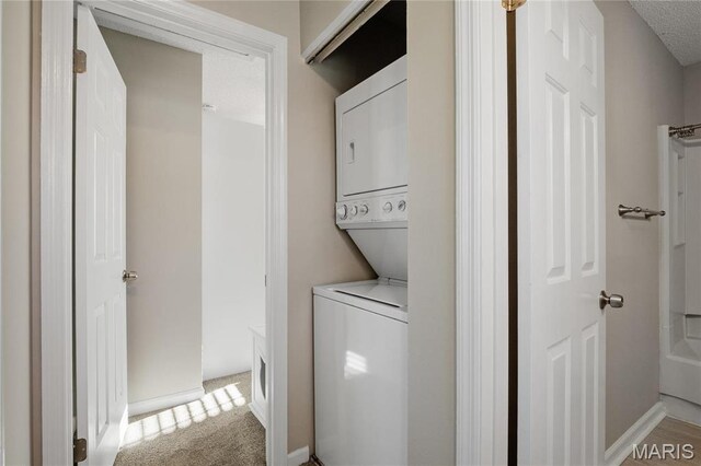 1508 Swallow Dr, Saint Louis, MO 63144 - laundry area featuring stacked washer / dryer, light colored carpet, and baseboards