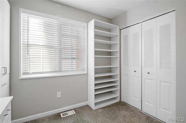 1508 Swallow Dr, Saint Louis, MO 63144 - unfurnished bedroom featuring carpet flooring, a closet, a textured ceiling, and baseboards