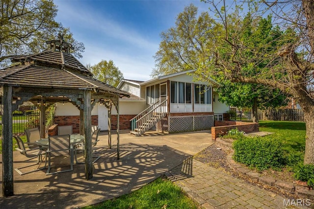 807 W Miller Dr, Staunton, IL 62088 - rear view of property featuring a sunroom, a patio area, fence, a gazebo, and brick siding