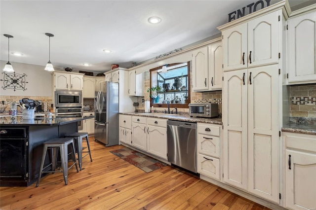 291 Deer Run Acres A, Williamsville, MO 63967 - kitchen with stainless steel appliances, a sink, backsplash, a kitchen breakfast bar, and hanging light fixtures