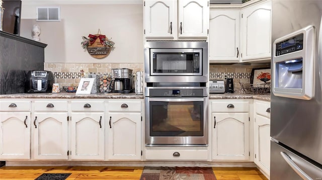 302 Deer Run Acres A, Williamsville, MO 63967 - kitchen with appliances with stainless steel finishes, decorative backsplash, light wood-style floors, and light countertops