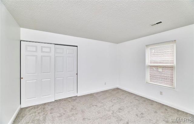 285 Mount Everest Dr, Fenton, MO 63026 - unfurnished bedroom featuring carpet floors, a textured ceiling, a closet, and baseboards
