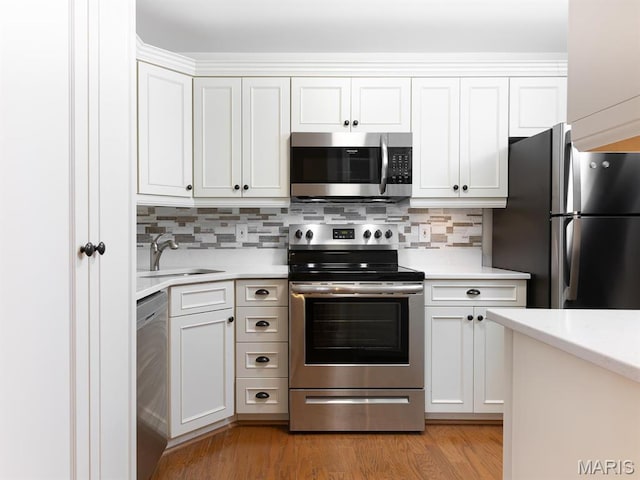 kitchen featuring appliances with stainless steel finishes, a sink, and light countertops