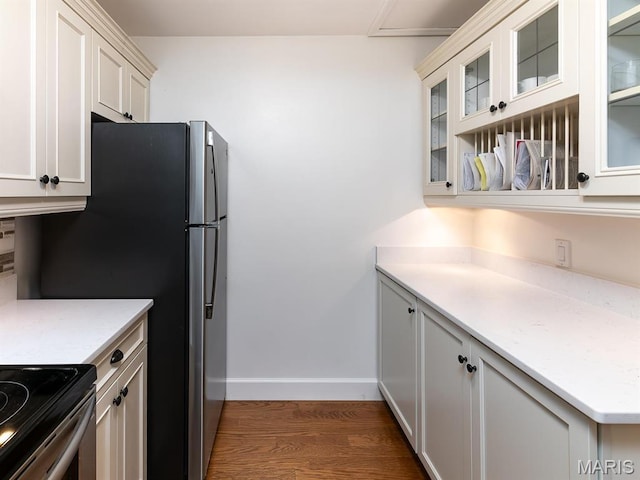 kitchen with dark wood-style floors, baseboards, light countertops, and glass insert cabinets