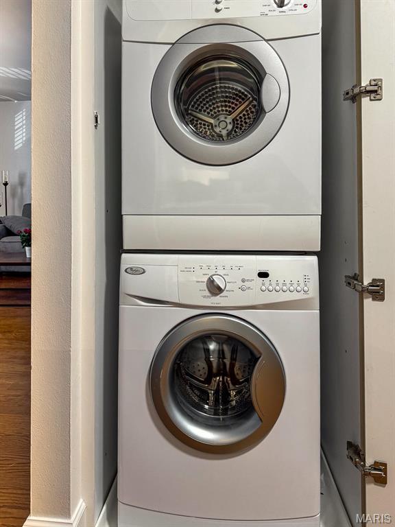 clothes washing area with stacked washer and clothes dryer