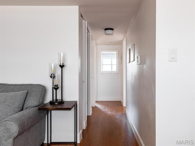 corridor with wood finished floors and baseboards