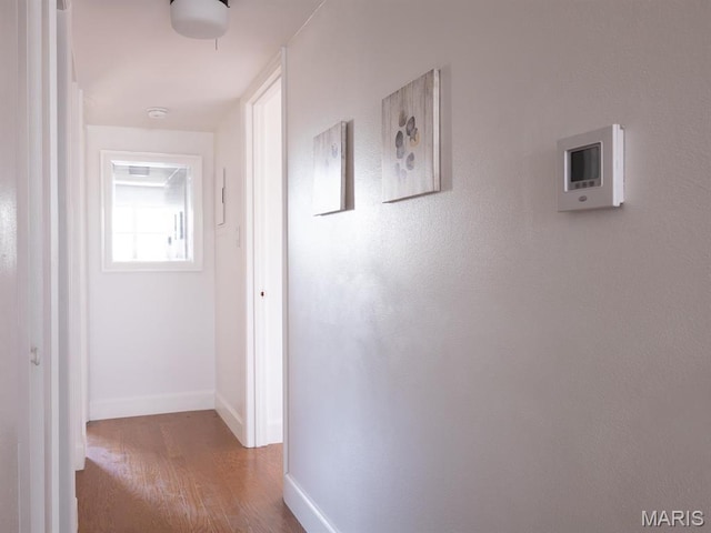 hallway featuring wood finished floors and baseboards