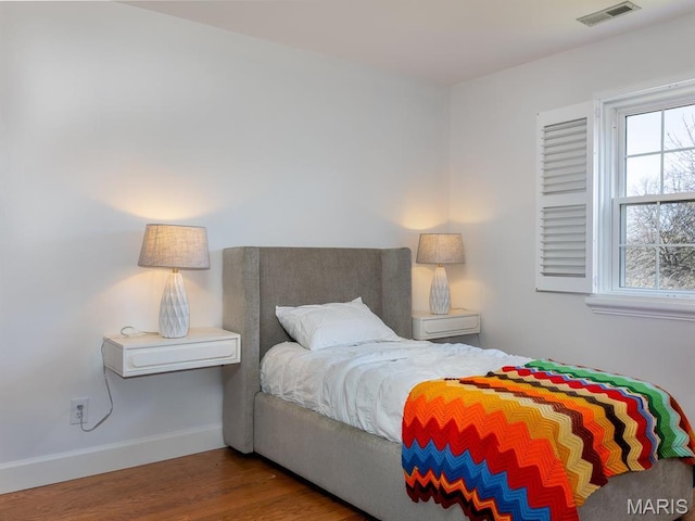 bedroom with wood finished floors and baseboards