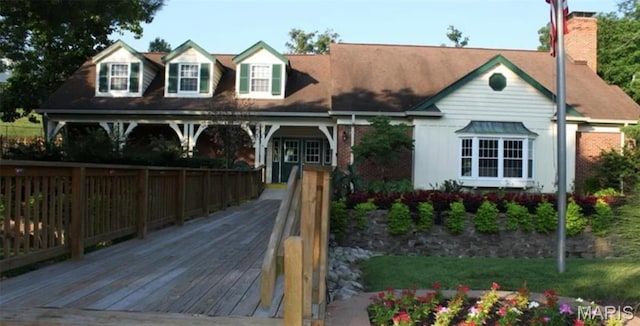 view of front facade featuring a chimney and a deck