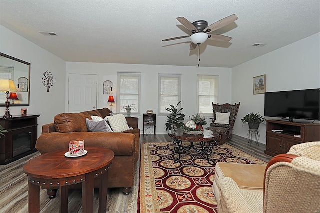 918 Susan St, Dexter, MO 63841 - living area featuring dark wood finished floors, a ceiling fan, a fireplace, and a textured ceiling