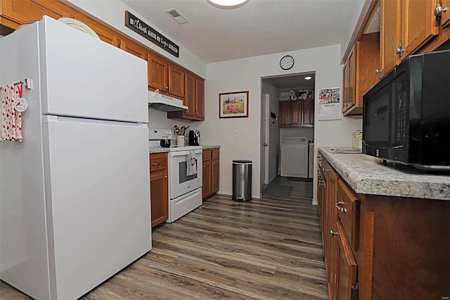 918 Susan St, Dexter, MO 63841 - kitchen with white appliances, washer / dryer, under cabinet range hood, dark wood-type flooring, and light countertops