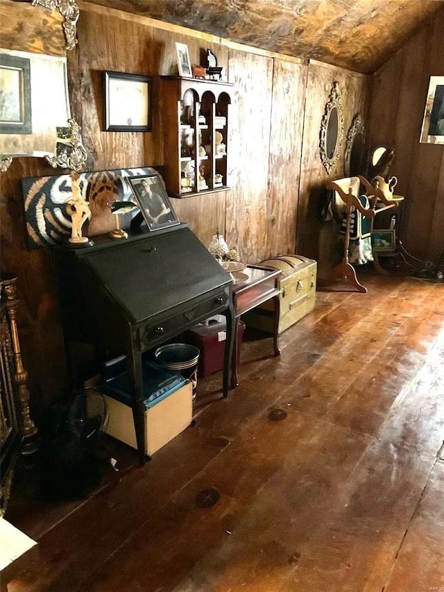 misc room featuring wooden walls, wood-type flooring, and lofted ceiling
