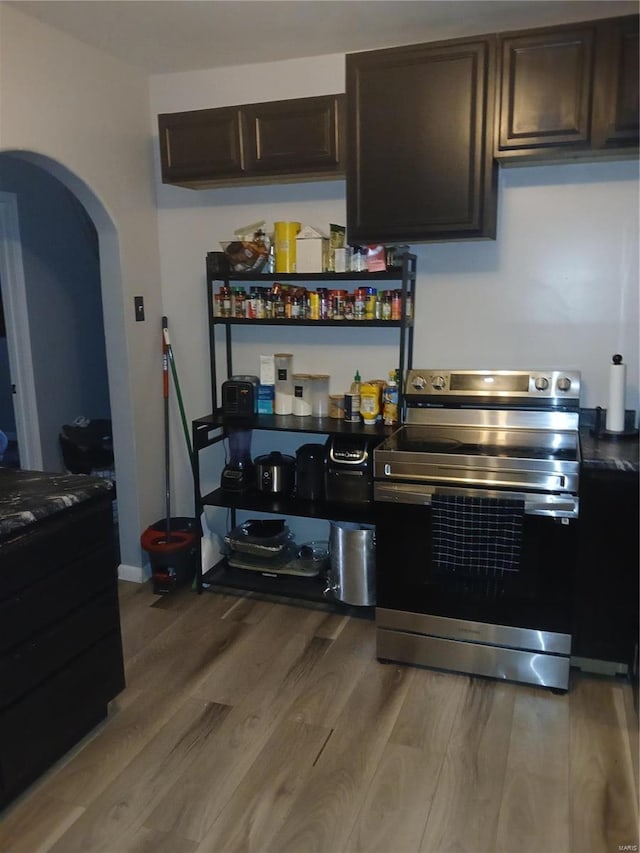 1018 N Hornsby, Saint Louis, MO 63147 - kitchen with stainless steel electric stove, wood finished floors, arched walkways, and dark brown cabinets