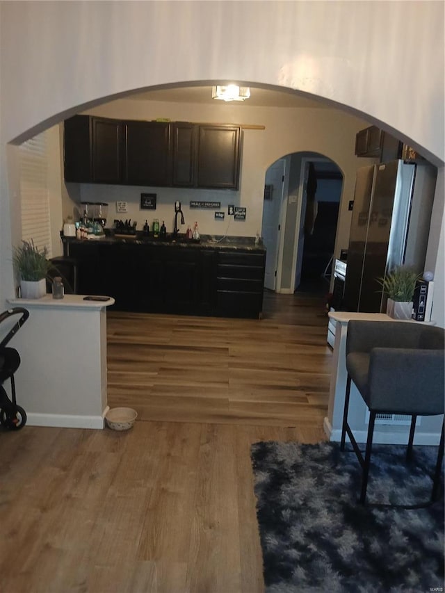1018 N Hornsby, Saint Louis, MO 63147 - kitchen with arched walkways, wood finished floors, and a sink