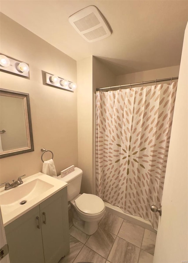 bathroom featuring vanity, toilet, and curtained shower