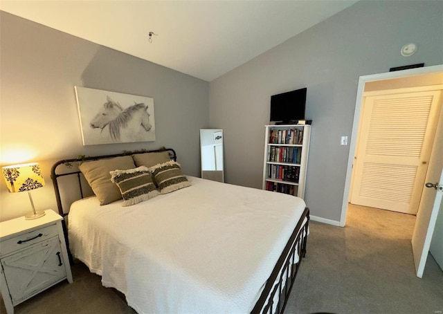 bedroom featuring vaulted ceiling, dark colored carpet, and baseboards