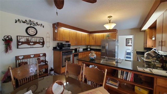 319 County Road 2270, Salem, MO 65560 - kitchen with stainless steel appliances, ceiling fan, dark countertops, a peninsula, and brown cabinetry