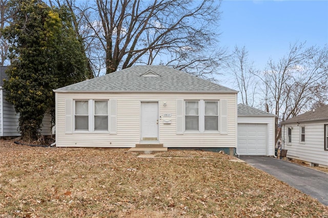 7719 Horatio Dr, Saint Louis, MO 63121 - view of front of house featuring roof with shingles, asphalt driveway, entry steps, and a detached garage