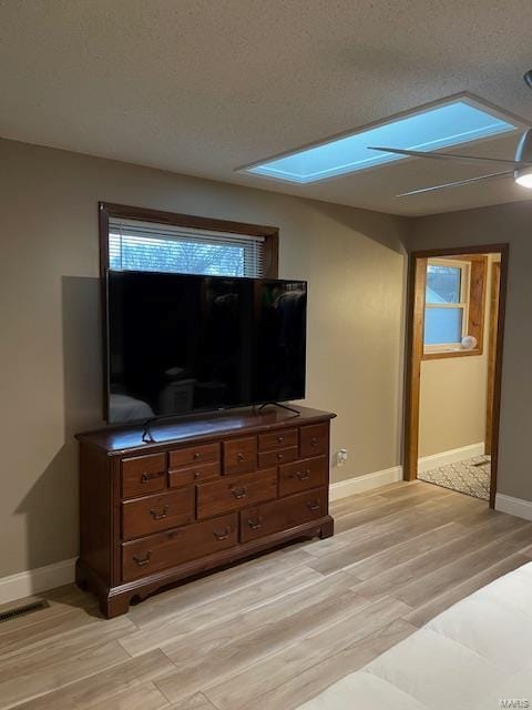 420 Joyce Ave, Bernie, MO 63822 - living area with baseboards, light wood-type flooring, a textured ceiling, and a skylight