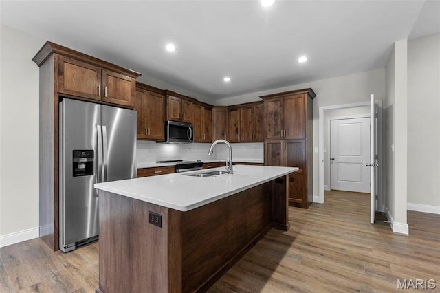 4 Creekside Way, Cape Girardeau, MO 63701 - kitchen with appliances with stainless steel finishes, light wood-type flooring, light countertops, decorative backsplash, and an island with sink