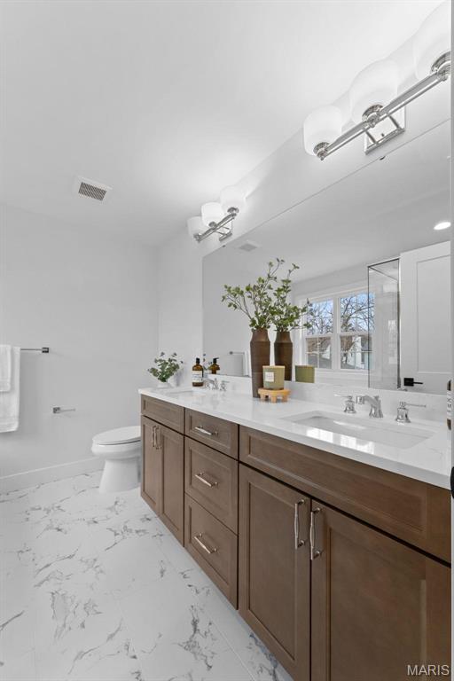 629 Simmons Ave, Saint Louis, MO 63122 - full bathroom featuring double vanity, marble finish floors, toilet, and a shower