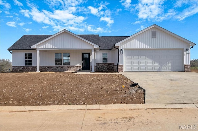 8 Bluebell Way, Jackson, MO 63755 - view of front of house featuring an attached garage, driveway, brick siding, and covered porch