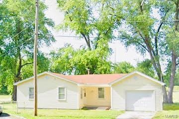 single story home with an attached garage, a front yard, and concrete driveway