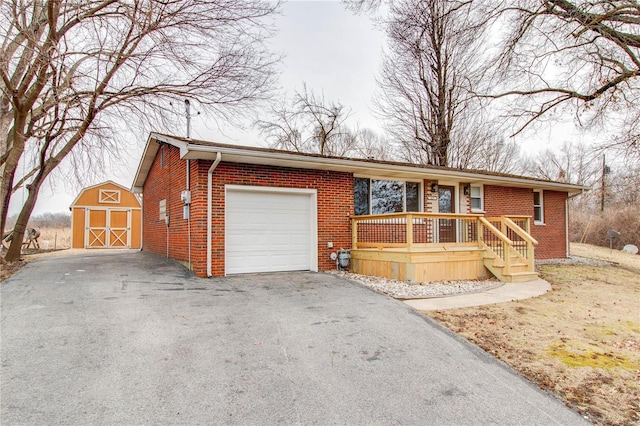 429 Oak St, East Alton, IL 62024 - ranch-style home with brick siding, a garage, a porch, asphalt driveway, and an outbuilding