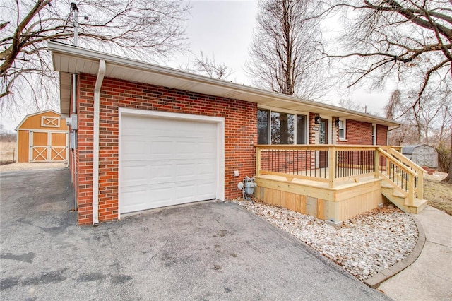 429 Oak St, East Alton, IL 62024 - ranch-style home featuring a shed, brick siding, asphalt driveway, a garage, and an outdoor structure