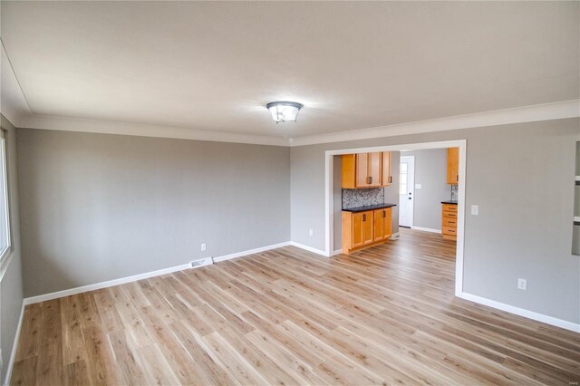 429 Oak St, East Alton, IL 62024 - unfurnished living room with crown molding, baseboards, and light wood-style floors