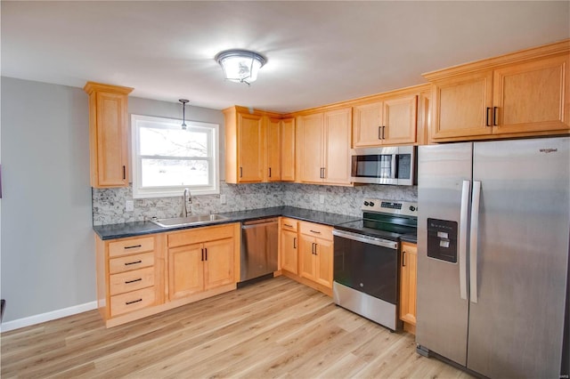 429 Oak St, East Alton, IL 62024 - kitchen with appliances with stainless steel finishes, a sink, dark countertops, backsplash, and light brown cabinets