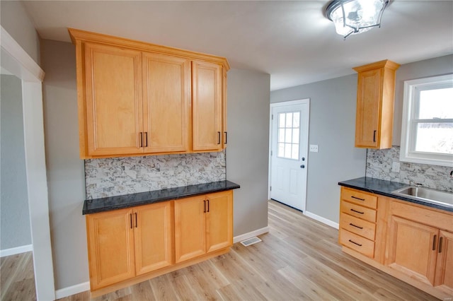 429 Oak St, East Alton, IL 62024 - kitchen featuring light brown cabinetry, decorative backsplash, and light wood finished floors