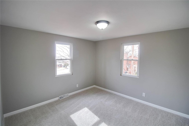 429 Oak St, East Alton, IL 62024 - spare room featuring plenty of natural light, carpet floors, and baseboards